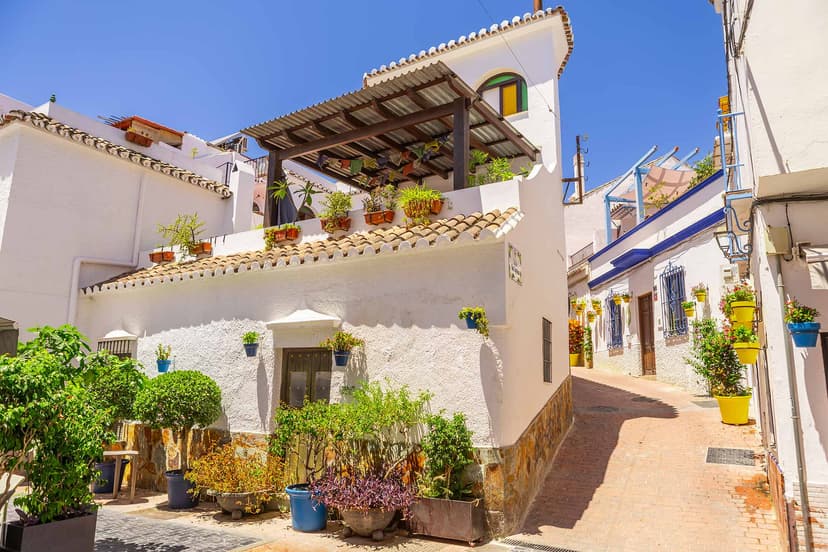 Calle típica del casco de Estepona, fachadas blancas con macetas, variante.
